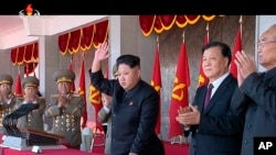 In an image made from video, North Korean leader Kim Jong Un, center, and Liu Yunshan, China's Communist Party's No. 5 leader, second right, waves during a ceremony to mark the 70th anniversary of the country's ruling party, in Pyongyang, Oct. 10, 2015. (KRT via AP Video) 