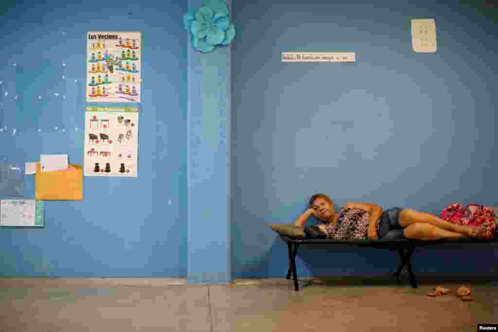 A woman rests in a school used as a shelter before the arrival of the Hurricane Maria in Guayama, Puerto Rico, Sept. 19, 2017.