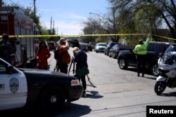 A police officer lifts crime scene tape to let in a car outside the scene of one of two bombings in Austin, Texas, March 12, 2018.