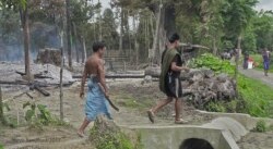 Men seen burning huts in the town of Maungdaw, Myanmar. (Photo: Steve Sandford / VOA)