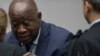 Former Ivory Coast President Laurent Gbagbo greets his legal team as he enters the courtroom of the International Criminal Court in The Hague, Netherlands, Jan. 15, 2019, where judges acquitted Gbagbo and ex-government minister Charles Ble Goude for lack 