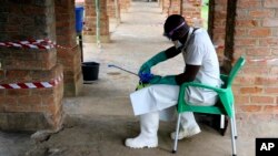 A health care worker wears virus protective gear at a treatment center in Bikoro, Democratic Republic of Congo, May 13, 2018. Congo's latest Ebola outbreak has spread to a city of more than 1 million people, a worrying shift as the deadly virus risks traveling more easily in densely populated areas. 