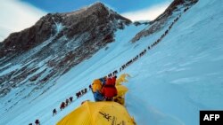Ova fotografija snimljena 31. maja 2021. prikazuje planinare poredane dok se penju uz padinu tokom uspona na vrh Mount Everesta (8.848,86 metara), u Nepalu. (Fotografija Lakpa SHERPA / AFP)