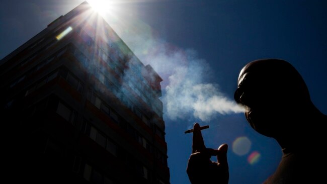 FILE - In this Jan. 18, 2012 photo, a smoker puffs on a cigarette in the central business district in Auckland, New Zealand.