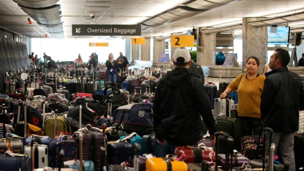 旅客们在美国丹佛国际机场西南航空公司的行李交运处等待（2022年12月27日）(photo:VOA)