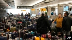 旅客们在美国丹佛国际机场西南航空公司的行李交运处等待（2022年12月27日）