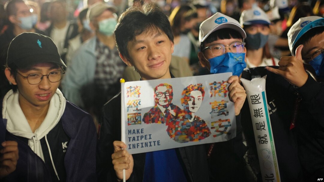 A supporter of the main opposition Kuomintang (KMT) and candidate Chiang Wan-an (not pictured) displays a placard during a mayoral election campaign rally in Taipei on Nov. 26, 2022.