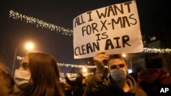 Seorang siswa sekolah menengah atas membawa poster yang berisi protes terhadap kualitas udara buruk yang melanda Skopje, Makedonia Utara, dalam sebuah aksi di Skopje, pada 20 Desember 2019. (Foto: AP/Boris Grdanoski)