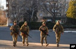 Ukrainian soldiers walk along a street in the area of the heaviest battles with the Russian invaders in Bakhmut, Ukraine, Dec. 20, 2022.