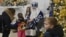 A man dressed as a Saint Nicholas and a woman dressed as an angel greet children at a public library in Irpin, northwest of Kyiv, on Dec. 23, 2022, amid the Russian invasion of Ukraine.