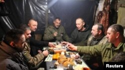 Ukrainian service members have their festive Christmas dinner, at an unknown location, Dec. 25, 2022. (Press Service of the General Staff of the Ukrainian Armed Forces/Handout via Reuters)