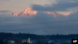 Alpine peaks which would normally be covered by snow are seen above the village of Naklo, Slovenia, Jan. 4, 2023.