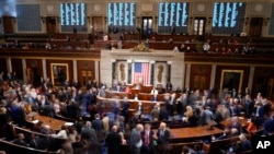 Members walk on the House floor in the House chamber during a roll call vote on the motion to adjourn as the House meets for a second day to elect a speaker and convene the 118th Congress in Washington, Jan. 4, 2023.