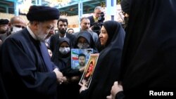 Iranian President Ebrahim Raisi meets with families of the security forces killed during Iran's protests, in Tehran, Iran, Dec. 9, 2022. (Presidential Website/WANA/Handout via Reuters)