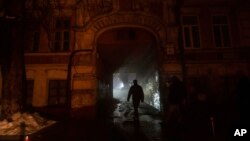 People walk at the city center, which lost electrical power after the previous day's Russian rocket attack, in Kyiv, Ukraine, Nov. 24, 2022.