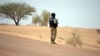 Un gendarme du Burkina Faso monte la garde au bord d'une route.