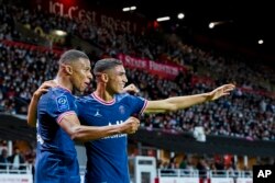 Kylian Mbappe dari PSG, kiri, merayakan dengan rekan setimnya Achraf Hakimi dari PSG di stadion Francis-Le Ble di Brest, Prancis, 20 Agustus 2021. Keduanya akan berhadapan di semifinal Piala Dunia 2022. (Foto: AP)