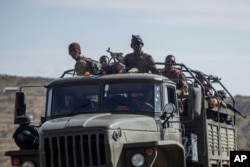 FILE - FILE - Ethiopian government soldiers ride in the back of a truck on a road near Agula, north of Mekele, in the Tigray region of northern Ethiopia, May 8, 2021.