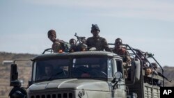 FILE - FILE - Ethiopian government soldiers ride in the back of a truck on a road near Agula, north of Mekele, in the Tigray region of northern Ethiopia, May 8, 2021. 