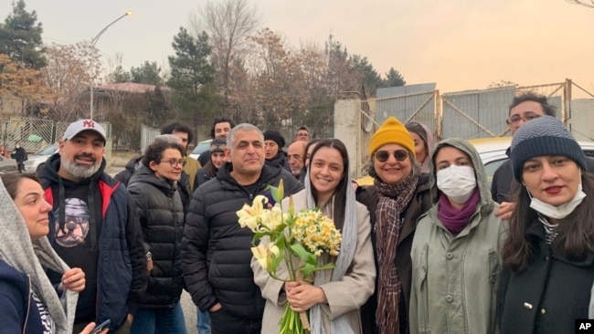 Iranian prominent actress Taraneh Alidoosti, center, holds bunches of flowers as she poses for a photo among her friends after being released from Evin prison in Tehran, Jan. 4, 2023. (Gisoo Faghfouri, Sharghdaily, via AP)