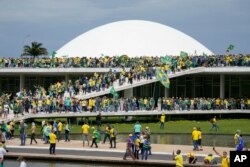 Pengunjuk rasa, pendukung mantan Presiden Brazil Jair Bolsonaro, menyerbu gedung Kongres Nasional di Brasilia, Brazil, Minggu, 8 Januari 2023. (Foto: AP/Eraldo Peres)