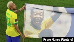 Le Brésilien Neymar porte une bannière à l'effigie de Pelé pendant la Coupe du monde au Qatar, le 5 décembre 2022.