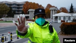 北京清华大学大门一名保安在阻止人们拍照。（2022年11月27日）