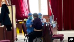 Medical workers vaccinate a man at a vaccination center in Beijing, Dec. 16, 2022.