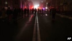 People walk through the city center which lost electrical power after yesterday's Russian rocket attack in Kyiv, Ukraine, Nov. 24, 2022.