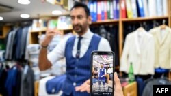 Roshan Melwani (Sam's Taylor) difilmkan oleh timnya saat berbicara dengan seorang klien di AS melalui panggilan video di tokonya di Hong Kong, 25 Oktober 2022. (Peter PARKS / AFP) 