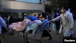 27일 중국 쓰촨성 청두에서 의료진이 코로나바이러스 감염 환자를 들것에 실어 이송하고 있다.