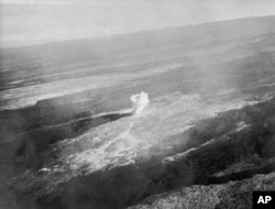 FILE - An aerial view of a bomb detonating on Mauna Loa near the 8500-foot elevation source of the 1935 lava flow on the morning of Dec. 27, 1935. (United States Army Air Corps, 11th Photo Section via AP)