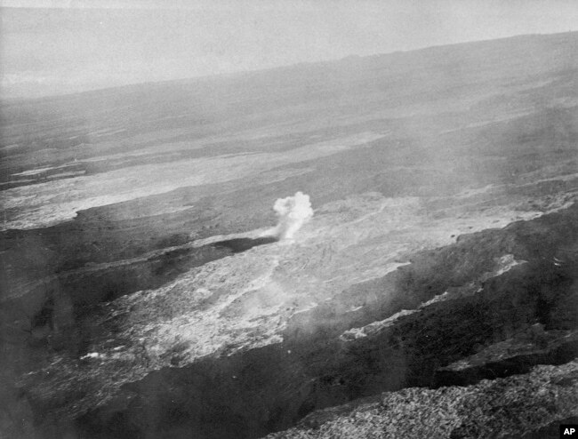 FILE - An aerial view of a bomb detonating on Mauna Loa near the 8500-foot elevation source of the 1935 lava flow on the morning of Dec. 27, 1935. (United States Army Air Corps, 11th Photo Section via AP)