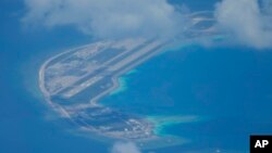 Sebuah lapangan terbang buatan China terlihat di samping bangunan dan bangunan di pulau buatan di Mischief Reef di gugusan Pulau Spratlys di Laut China Selatan pada 20 Maret 2022. (Foto: AP)