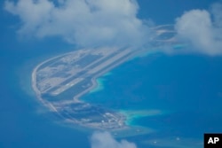 Sebuah lapangan terbang buatan China terlihat di samping bangunan dan bangunan di pulau buatan di Mischief Reef di gugusan pulau Spratlys di Laut China Selatan pada 20 Maret 2022. (Foto: AP)