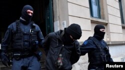 La policía detiene a un sospechoso durante redadas en varios lugares de Dresden, Alemania, el 15 de diciembre de 2021, como parte de una investigación sobre lo que las autoridades dicen era un complot para asesinar al primer ministro del estado, Michael Kretschmer, por parte de activistas contra la vacunación.