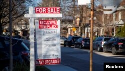 FILE - A realtor's "for sale" sign is posted outside a home in Toronto, Canada, Dec. 13, 2021. 