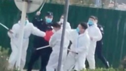 中国河南郑州富士康代工厂里身穿防护服的警察和保安殴打参加示威活动的工人。(2022年11月23日)