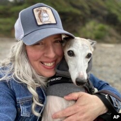 FILE - This photo provided by Amy Watson of Portland, Ore., shows her with her dog during a trip to the Oregon Coast in June 2022.
