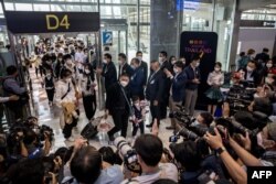 Members of the media record travelers from a Xiamen Airlines flight arriving at Suvarnabhumi Airport in Bangkok, Jan. 9, 2023.