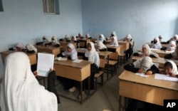 FILE - Afghan girls attend school classes in a primary school in Kabul, Afghanistan, Saturday, March 27, 2021.(AP Photo/Rahmat Gul, File)