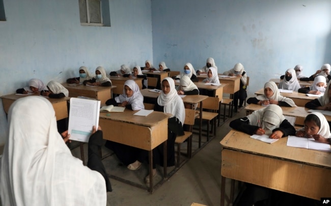 FILE - Afghan girls attend school classes in a primary school in Kabul, Afghanistan, Saturday, March 27, 2021.(AP Photo/Rahmat Gul, File)