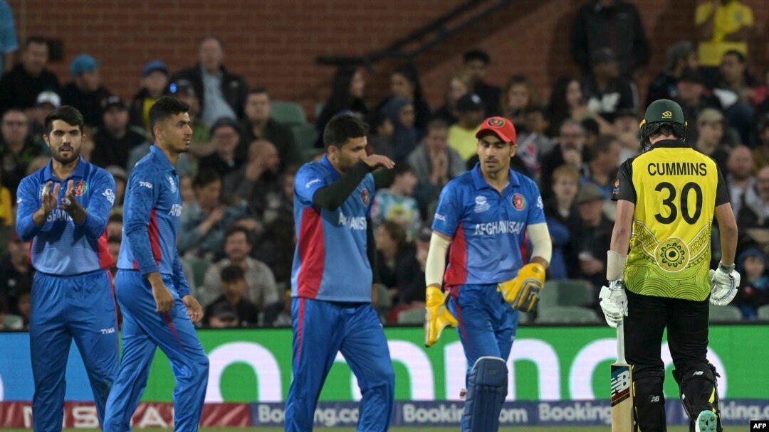 Pemain kriket Australia, Pat Cummins (kanan) meninggalkan lapangan saat berlangsungnya pertandingan Piala Dunia ICC 2022 antara Australia dan Afghanistan di Adelaide Oval, Adelaide, Australia. 4 November 2022. (Brenton EDWARDS / AFP)