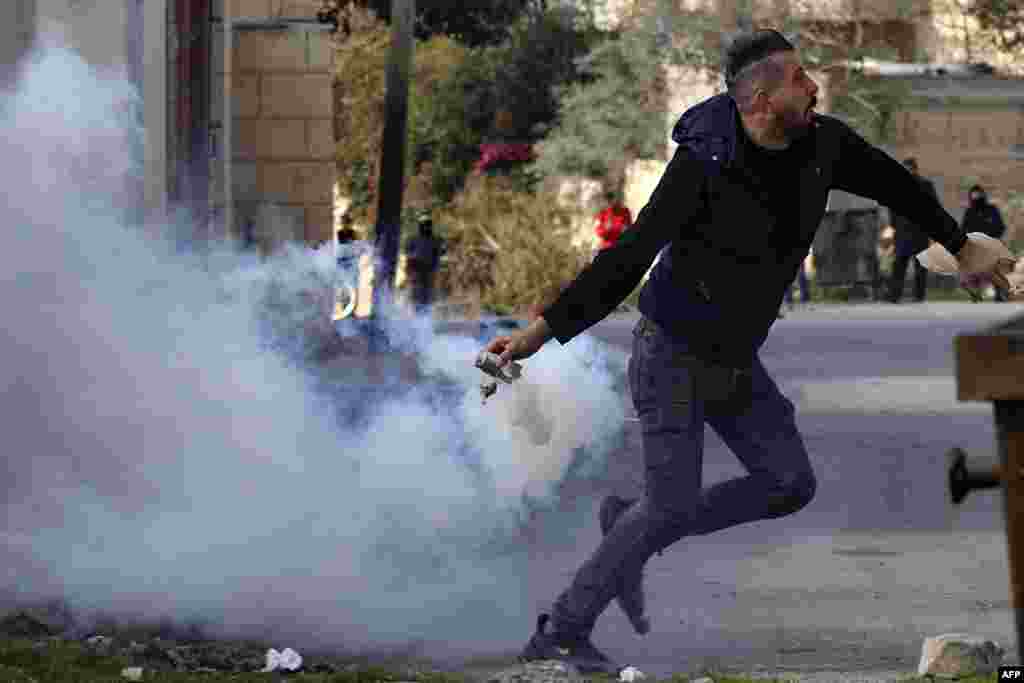 Falastinlik namoyishchi Isroil askarlari uloqtirgan ko&lsquo;zni yoshlantiruvchi vositani o&rsquo;ziga qaytarib otmoqda. G&rsquo;arbiy sohil.