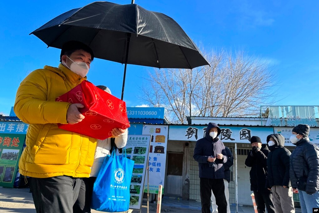 一名男子手捧亲人骨灰盒走出一家北京火葬场。（2022年12月17日）(photo:VOA)