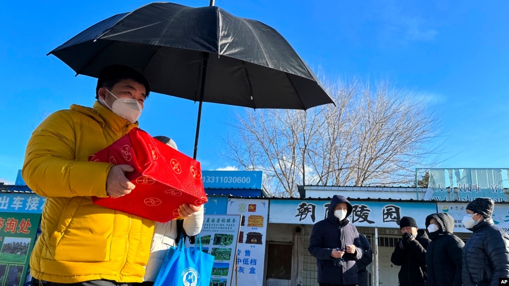 一名男子手捧亲人骨灰盒走出一家北京火葬场。（2022年12月17日）(photo:VOA)
