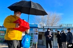 一名男子手捧親人骨灰盒走出一家北京火葬場。（2022年12月17日）
