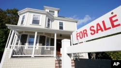 Tanda dijual tampak di depan sebuah rumah di kota Westwood, Massachusetts, AS (foto: ilustrasi).