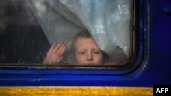 A child looks through the window of an evacuation train in the Donetsk region on Nov. 30, 2022, during the Russian invasion of Ukraine.