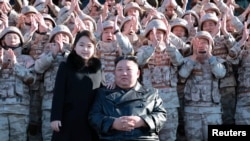 Pemimpin Korea Utara Kim Jong Un bersama dengan putrinya berfoto bersama sejumlah ilmuwan, insinyur, dan anggota militer Korea Utara. Foto dirilis oleh media pemerintah Korea Utara pada 27 November 2022. (Foto: KCNA via Reuters)